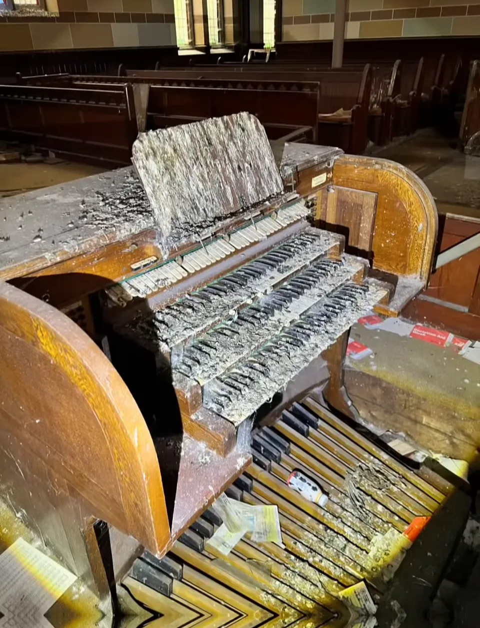 The organ console, its keys and stops broken and covered in debris