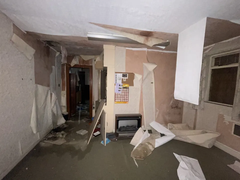 A gutted room with debris on the floor
