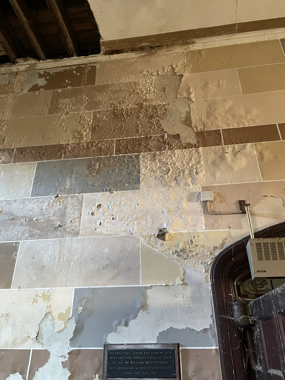 Peeling plaster and damp on an inside wall